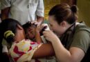 U.S. Navy Lt. Karen Mayr, Combat Logistics Battalion 31, 31st Marine Expeditionary Unit, checks the ears of a boy she suspects has an ear infection, Q