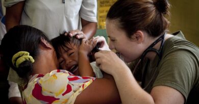 U.S. Navy Lt. Karen Mayr, Combat Logistics Battalion 31, 31st Marine Expeditionary Unit, checks the ears of a boy she suspects has an ear infection, Q