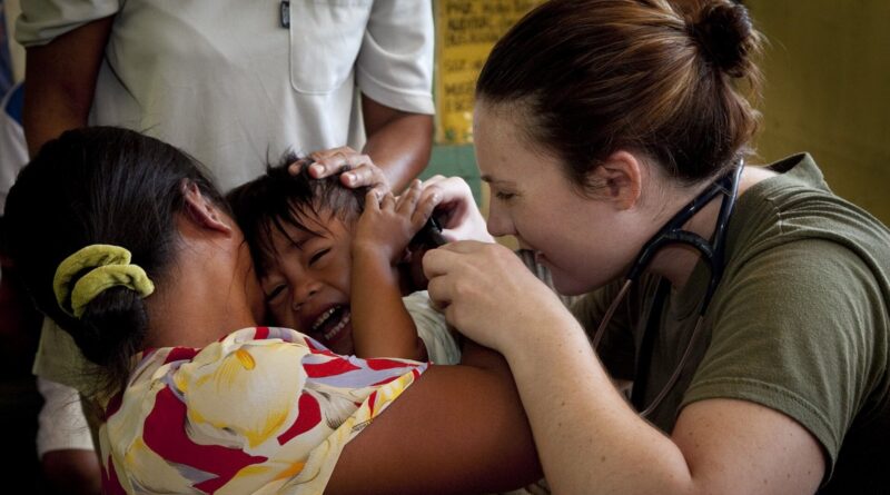 U.S. Navy Lt. Karen Mayr, Combat Logistics Battalion 31, 31st Marine Expeditionary Unit, checks the ears of a boy she suspects has an ear infection, Q