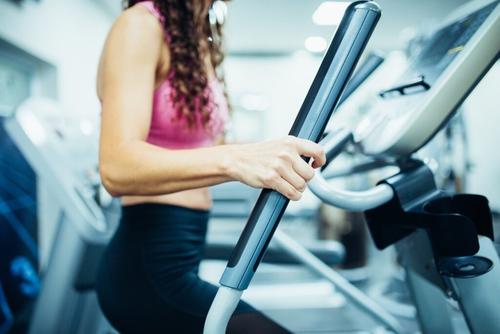 Close up of hands of a fit woman in the gym, exercising legs doing cardio workout